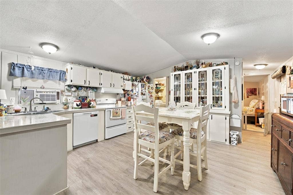 365 Beaver Lane, Waco, TX 76705 Kitchen featuring wood-finish flooring, white cabinetry, and a built-in display cabinet