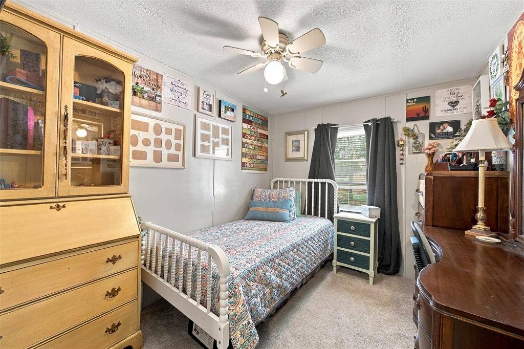 365 Beaver Lane, Waco, TX 76705 Carpeted room featuring a ceiling fan, a window with dark curtains, and light-colored walls