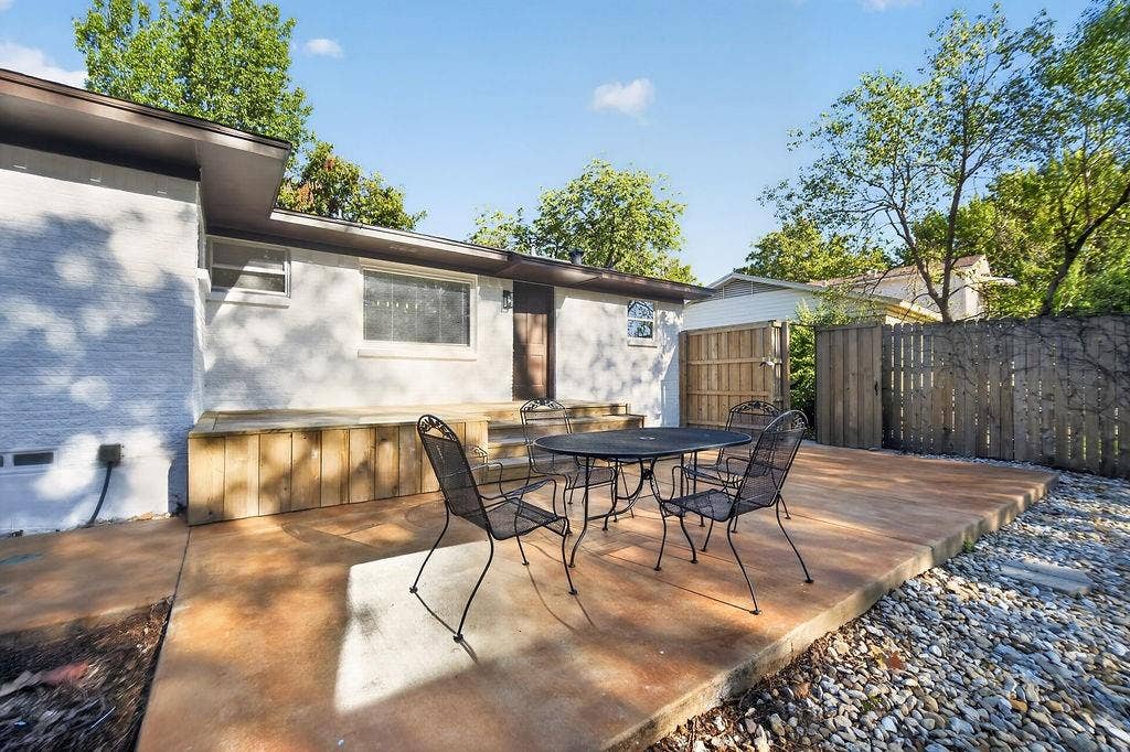 9112 Clearwater Drive, Dallas, TX 75243 Expansive concrete patio with a detached building and wood privacy fencing