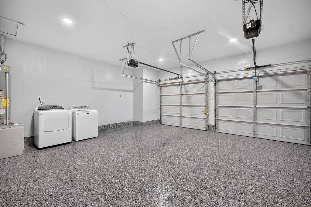 9112 Clearwater Drive, Dallas, TX 75243 Dual garage doors with automatic openers, speckled epoxy flooring, and recessed ceiling lighting
