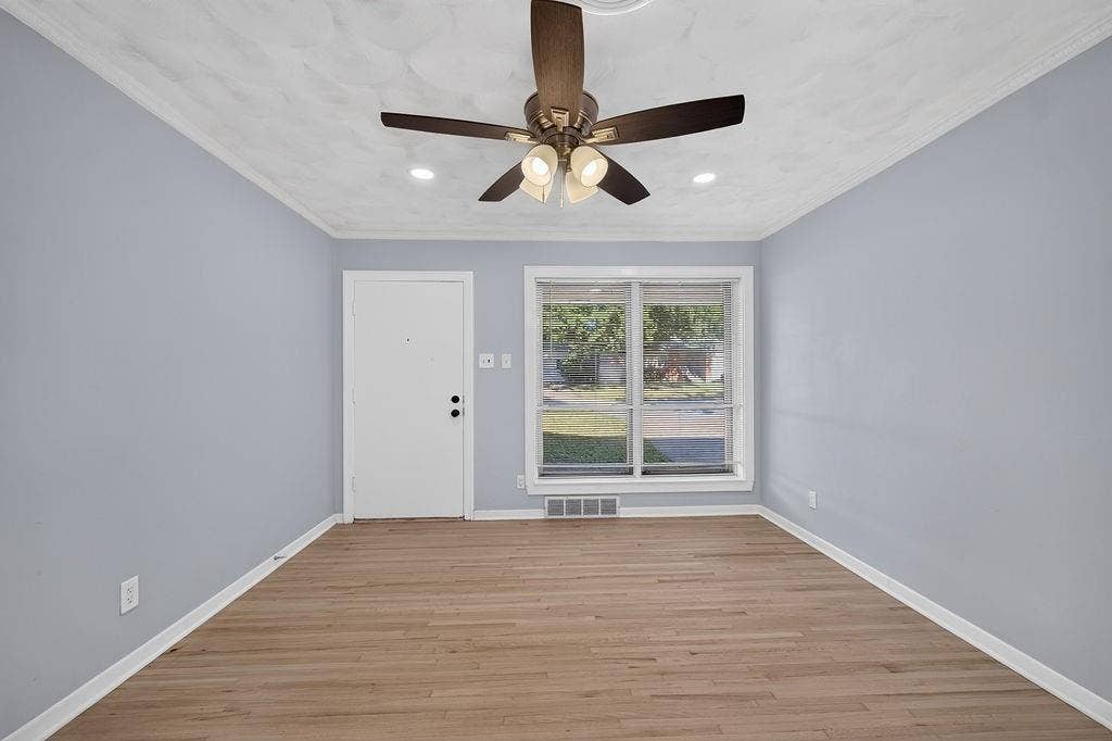 9112 Clearwater Drive, Dallas, TX 75243 Wood-finish flooring with light blue walls, a white entry door, and a multi-pane window