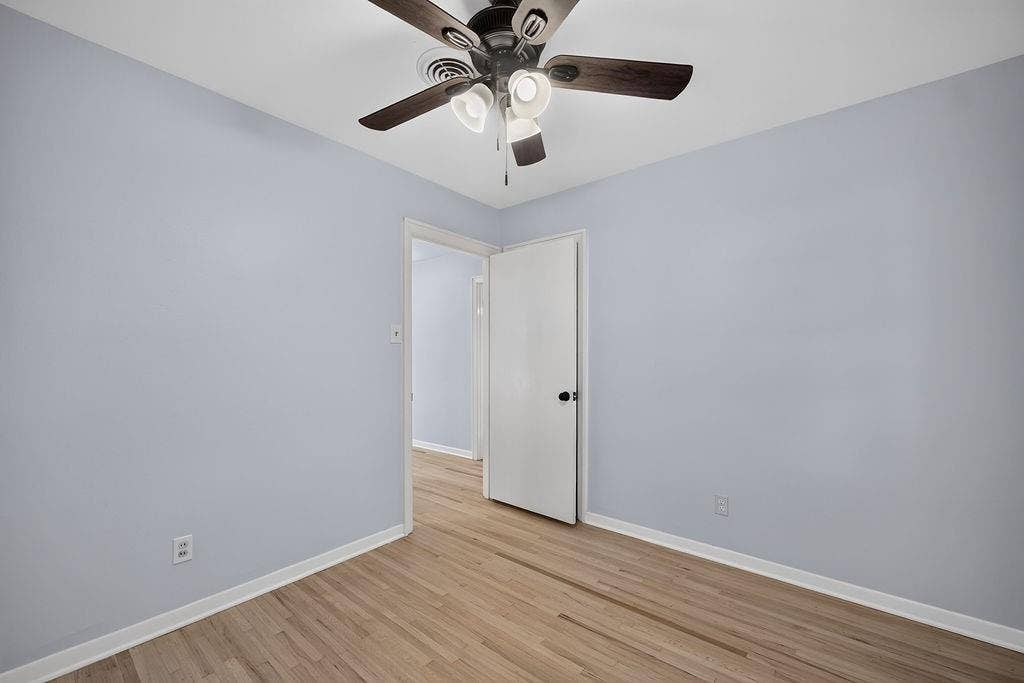 9112 Clearwater Drive, Dallas, TX 75243 Wood-finish flooring, light-toned walls, and a ceiling fan with integrated lighting