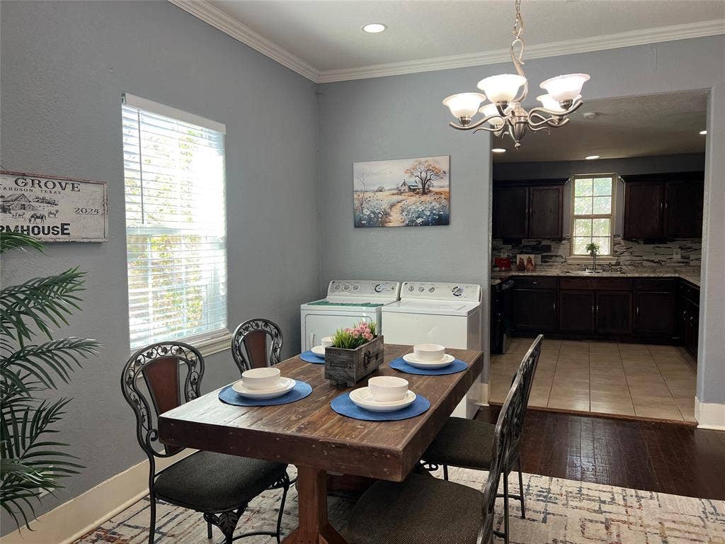 3227 Avenue I, Fort Worth, TX 76105 Dining area featuring wood-finish flooring, crown molding, and a chandelier
