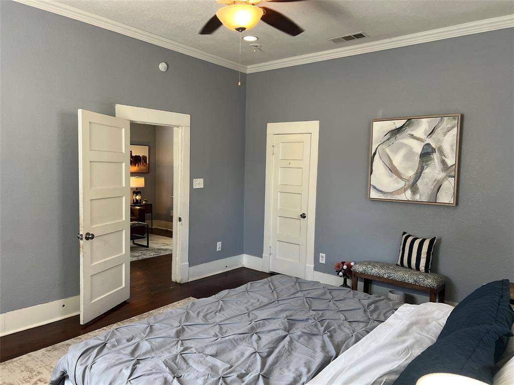3227 Avenue I, Fort Worth, TX 76105 Hardwood flooring and crown molding accent the space, complemented by a ceiling fan with integrated lighting