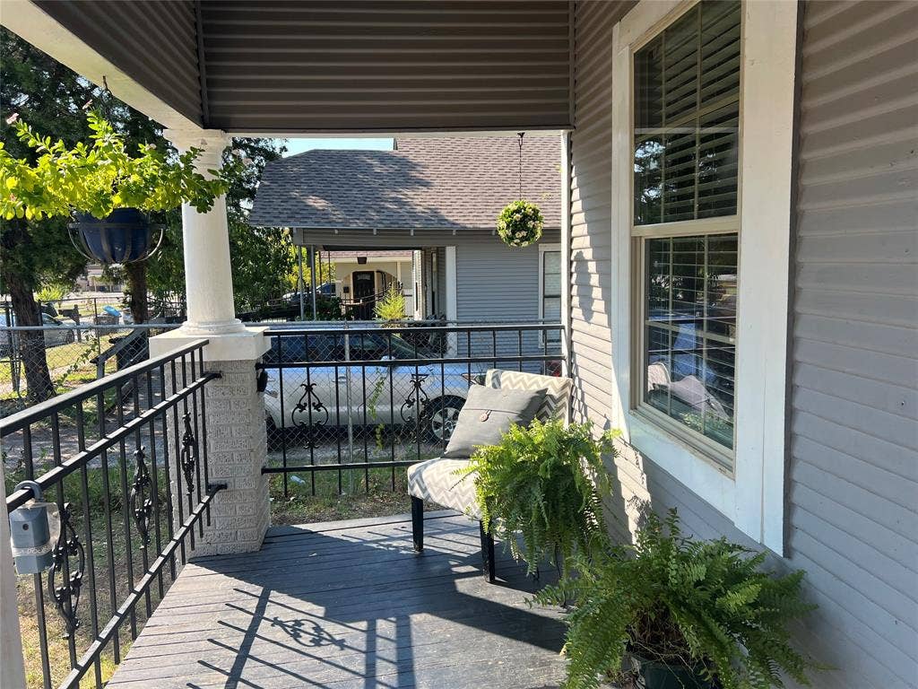 3227 Avenue I, Fort Worth, TX 76105 Front porch featuring a corrugated ceiling, decorative wrought iron railing, and a window with white trim