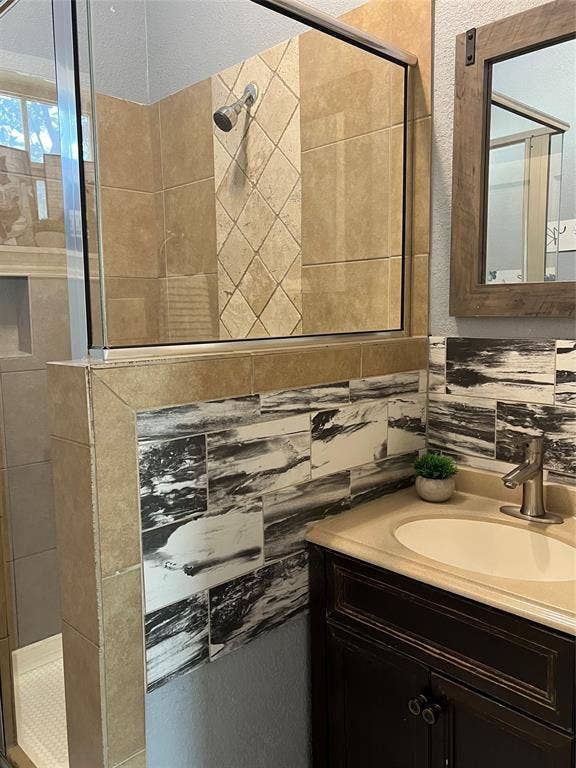 3227 Avenue I, Fort Worth, TX 76105 Glass-enclosed shower with tiled walls and a diagonal accent band