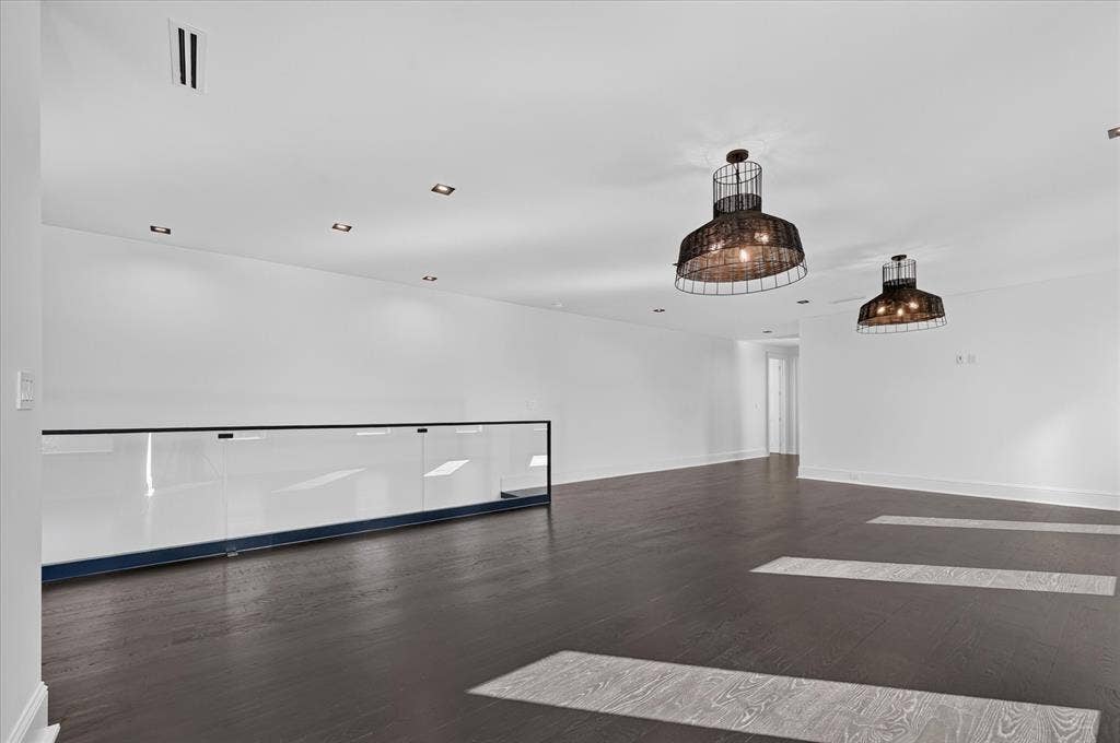 6404 Lakehurst Avenue, Dallas, TX 75230 Dark wood-finish flooring, recessed lighting, and modern wire-cage pendant lights