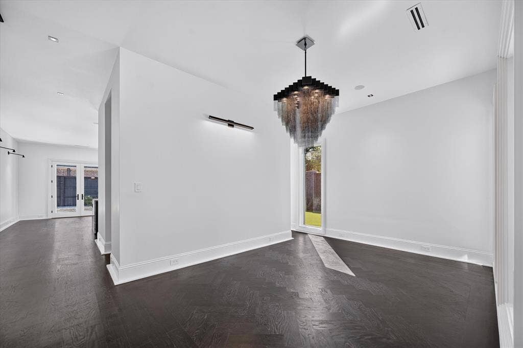 6404 Lakehurst Avenue, Dallas, TX 75230 Dark wood-finish flooring with a light-colored inset, modern chandelier, recessed lighting, and a linear wall sconce