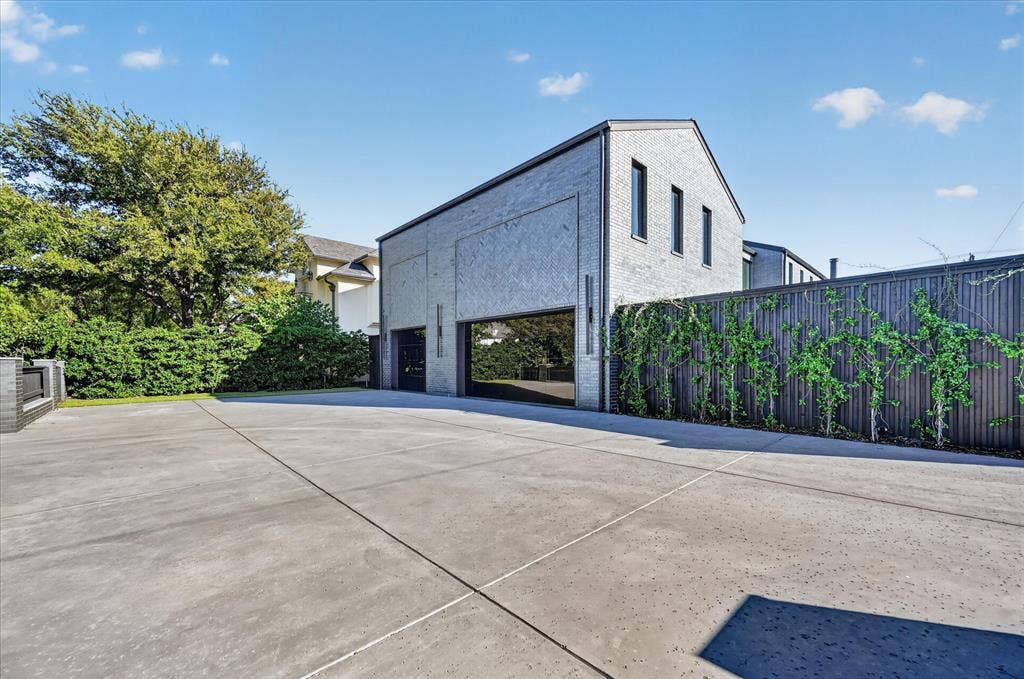 6404 Lakehurst Avenue, Dallas, TX 75230 Gray brick exterior featuring multiple windows and a metal roof