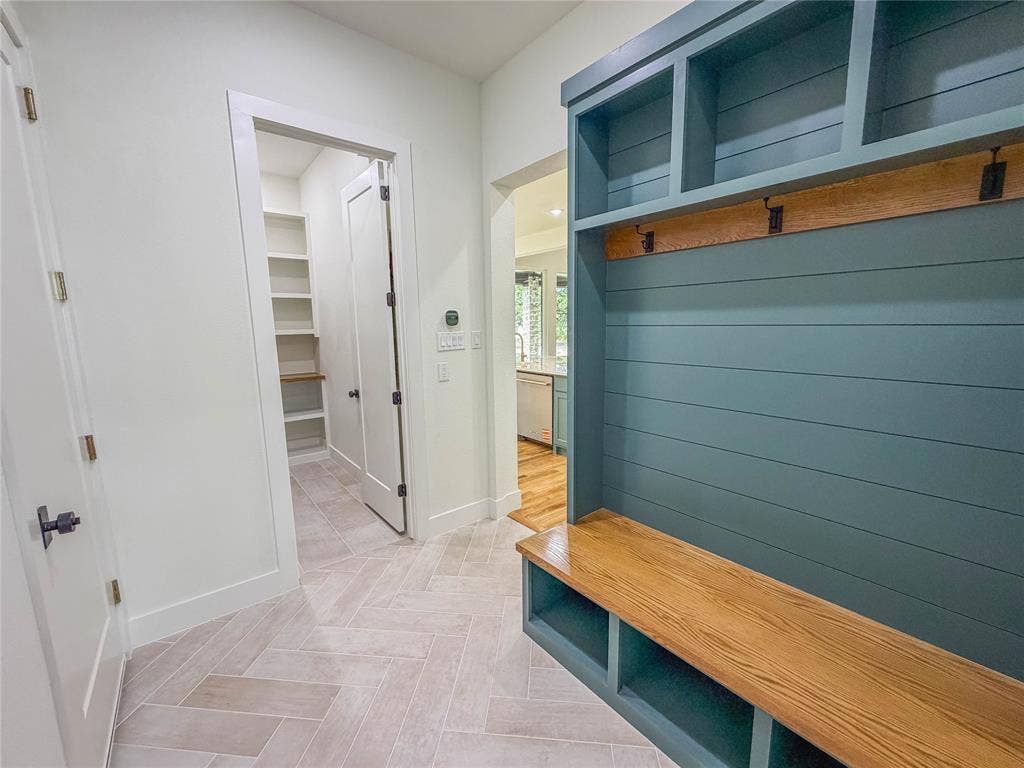 3860 Jacks Loop, Midlothian, TX 76065 Herringbone tile flooring, built-in storage bench with wood top, teal shiplap detailing, overhead shelving, and a dedicated pantry