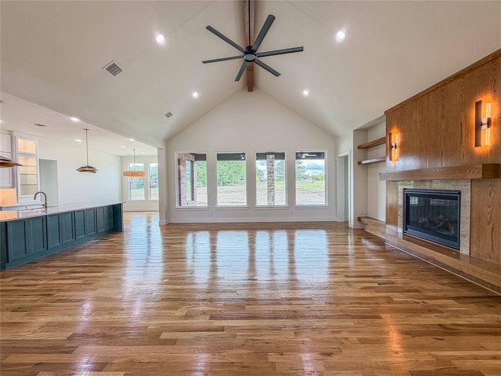 3860 Jacks Loop, Midlothian, TX 76065 Vaulted ceilings with exposed beam, wood-finish flooring, built-in fireplace with wood mantel, large island with integrated sink, and recessed lighting