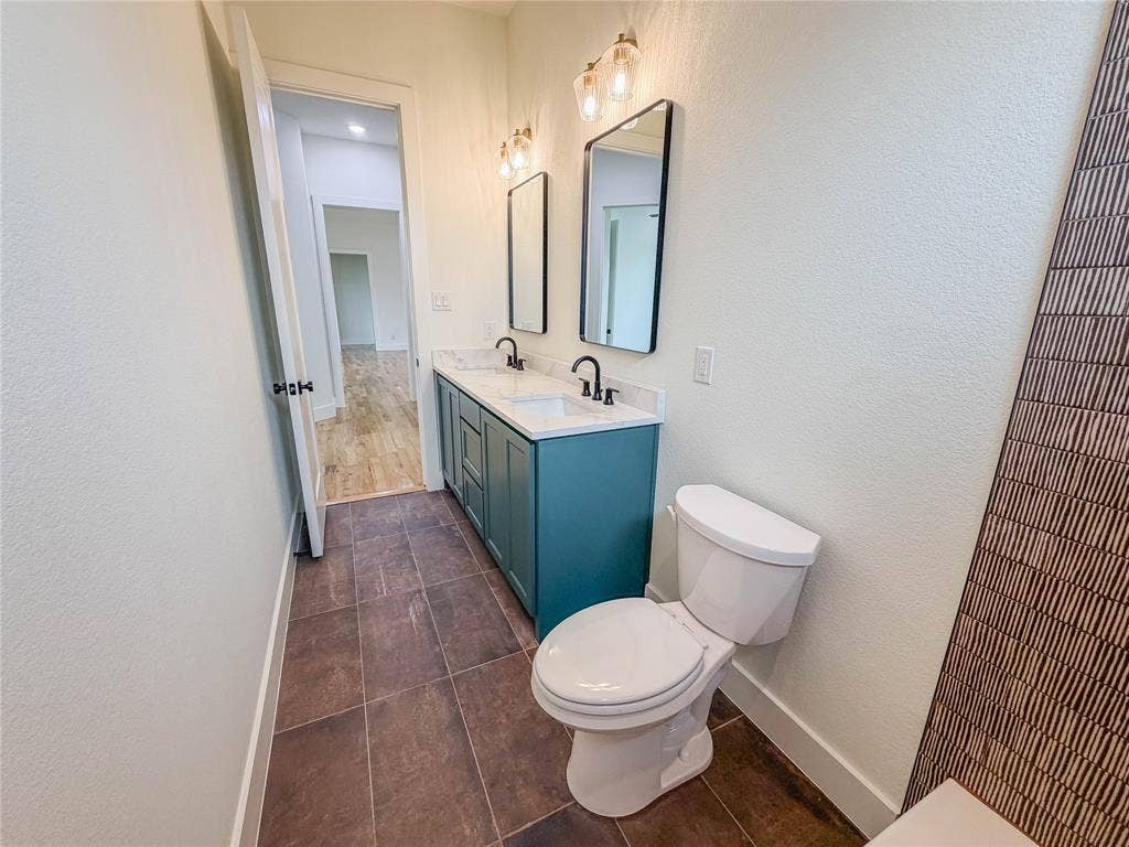 3860 Jacks Loop, Midlothian, TX 76065 Walk-in shower with clear glass enclosure and black hardware, patterned floor tile, single vanity with dark countertop, and rectangular undermount sink