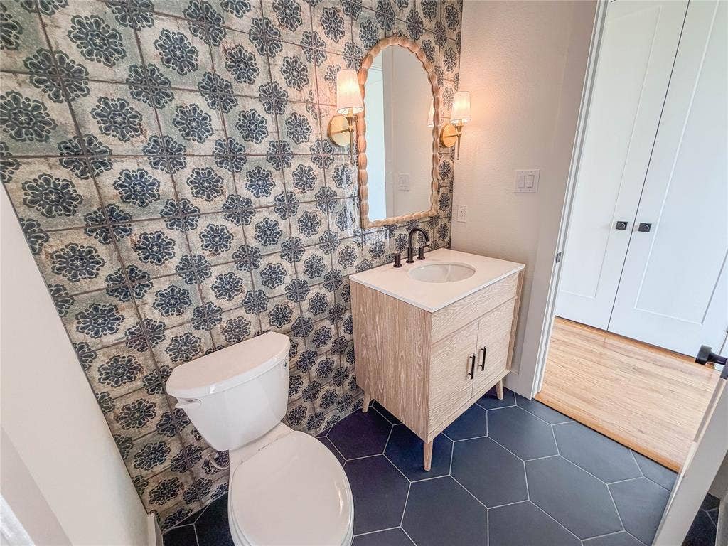 3860 Jacks Loop, Midlothian, TX 76065 Powder room featuring a patterned accent wall, hexagon floor tiles, and a contemporary vanity with a wall-mounted mirror