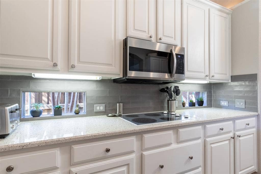 Kitchen with under-cabinet lighting and electric cooktop.