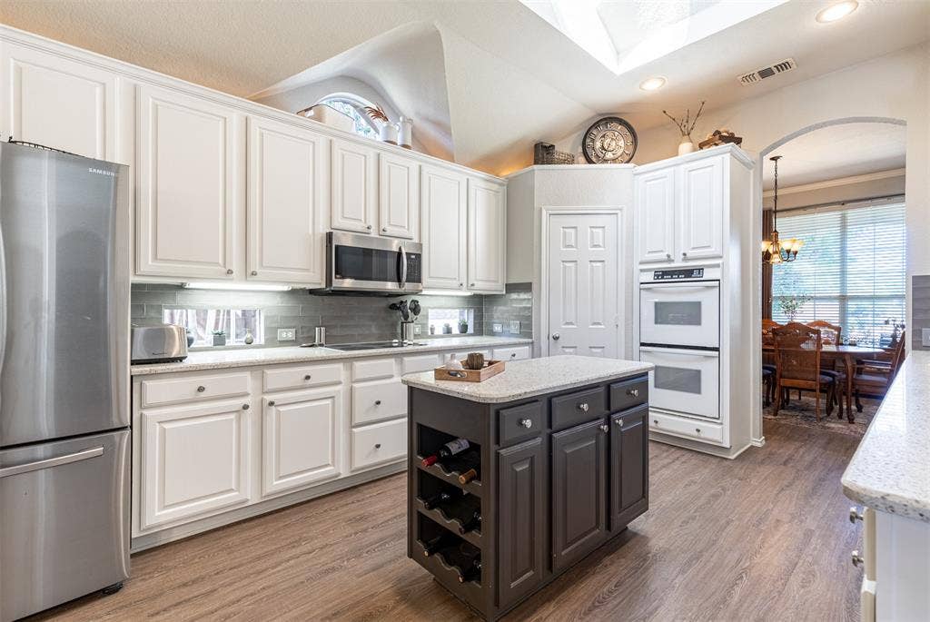 Gourmet kitchen features prep island with wine storage.