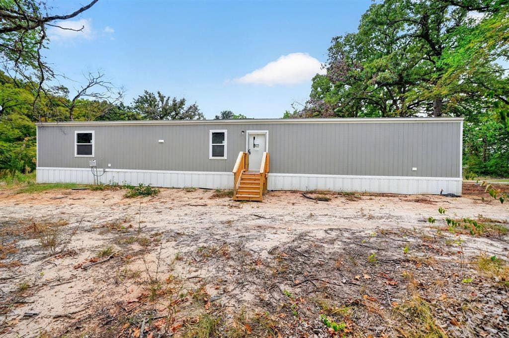 216 W Acres Road, Gun Barrel City, TX 75156 Light gray siding with white trim and white windows