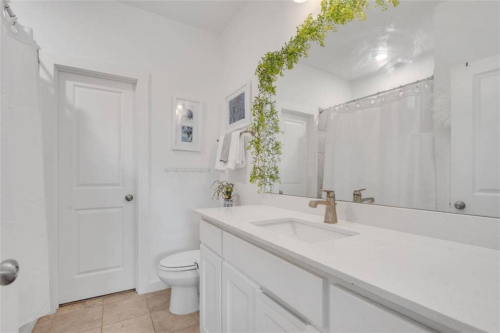 525 Division Street, Plano, TX 75075 White vanity with integrated sink, quartz countertop, and brushed nickel faucet