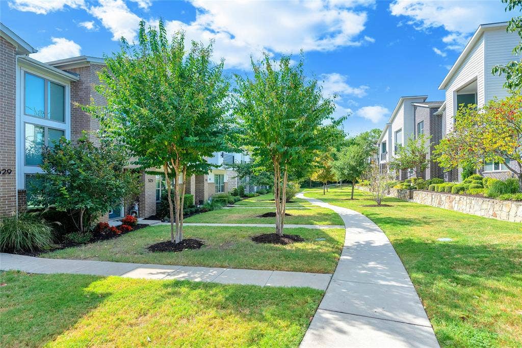 525 Division Street, Plano, TX 75075 Manicured green spaces with mature trees and a curving concrete pathway