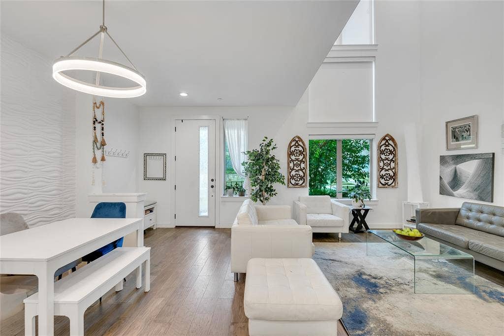 525 Division Street, Plano, TX 75075 Open-concept living space with wood-finish flooring, soaring ceilings, and a contemporary pendant light fixture