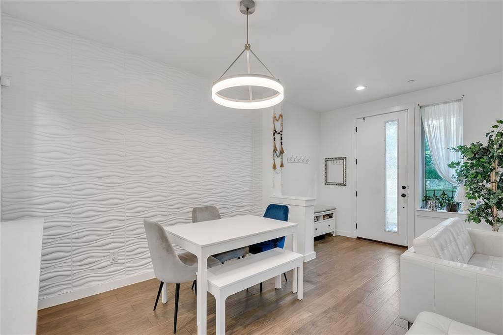 525 Division Street, Plano, TX 75075 Wood-finish flooring, textured accent wall, recessed lighting, and a modern circular pendant light