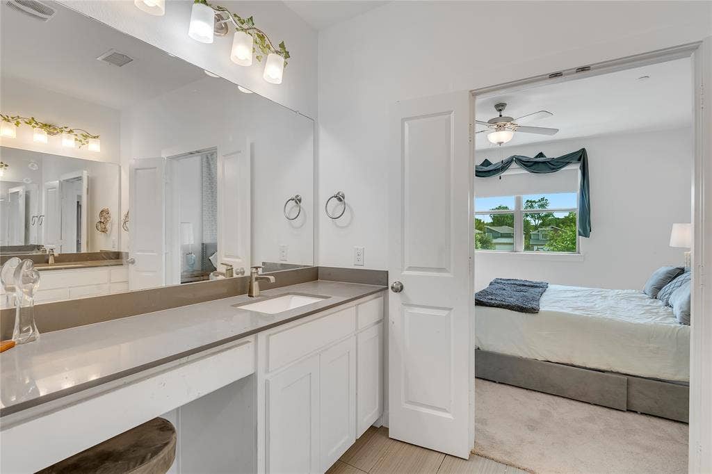 525 Division Street, Plano, TX 75075 Expansive vanity featuring a single basin sink, brushed nickel faucet, large mirror, and ample under-counter storage