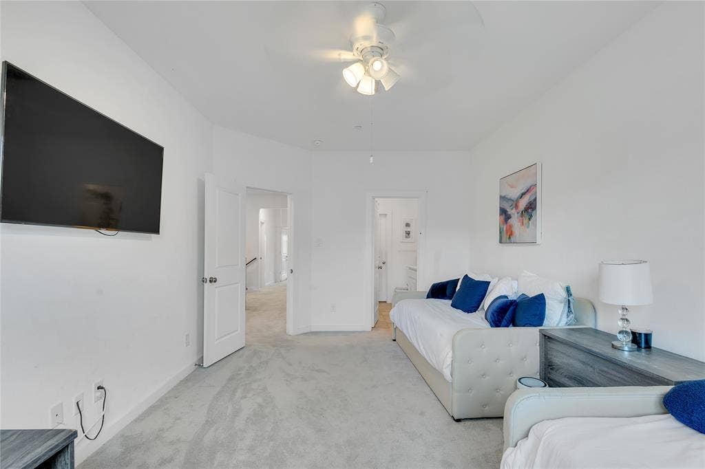 525 Division Street, Plano, TX 75075 Carpeted room with a ceiling fan, featuring white walls and a wall-mounted display