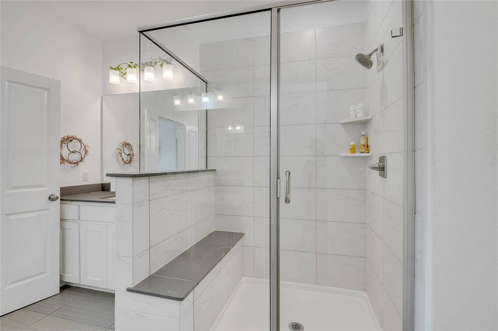 525 Division Street, Plano, TX 75075 Glass-enclosed shower with a built-in bench and integrated shelving