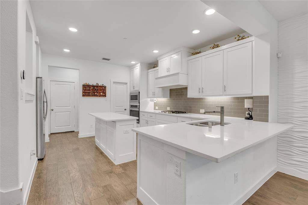 525 Division Street, Plano, TX 75075 Kitchen featuring white cabinetry, light-toned wood-finish flooring, recessed lighting, and white countertops