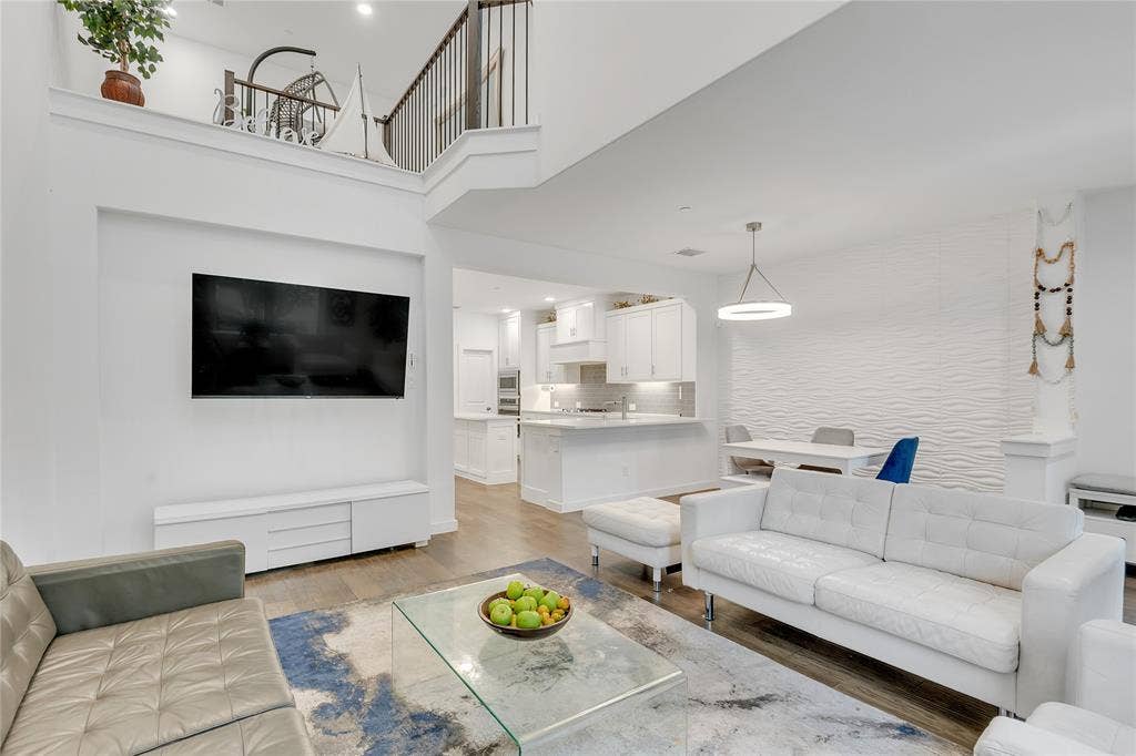 525 Division Street, Plano, TX 75075 Open-concept living area with wood-finish flooring, a contemporary accent wall, and a built-in media console