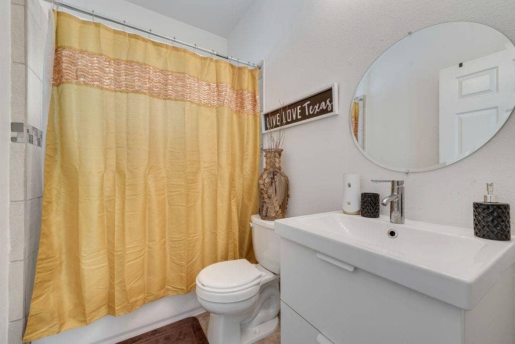 White wall-mounted vanity with integrated sink, chrome faucet, and oval mirror