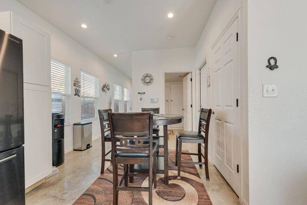 Recessed lighting, multiple windows with blinds, panel doors, and concrete-finish flooring