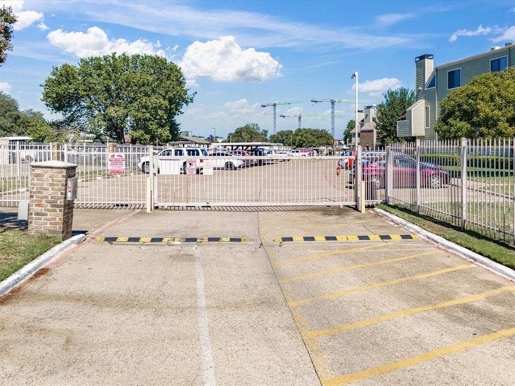 3129 Sondra Drive, #206, Fort Worth, TX 76107 Gated entry with a brick-clad pillar and white metal fencing