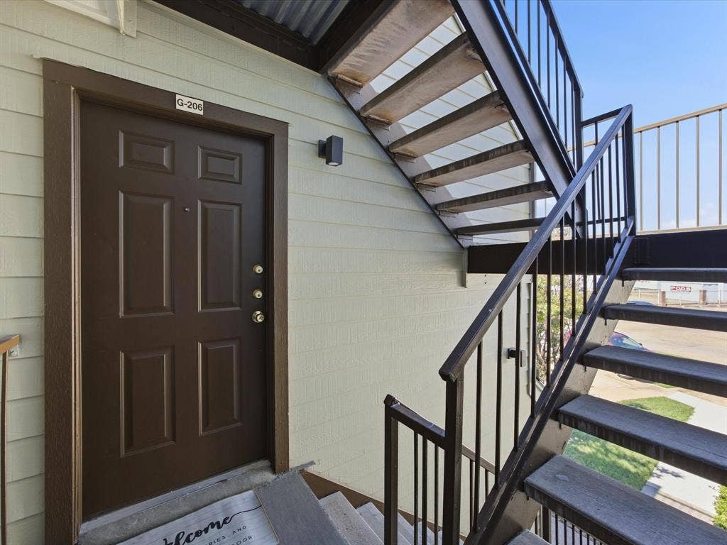 3129 Sondra Drive, #206, Fort Worth, TX 76107 Panel door entry with a wall-mounted exterior light fixture
