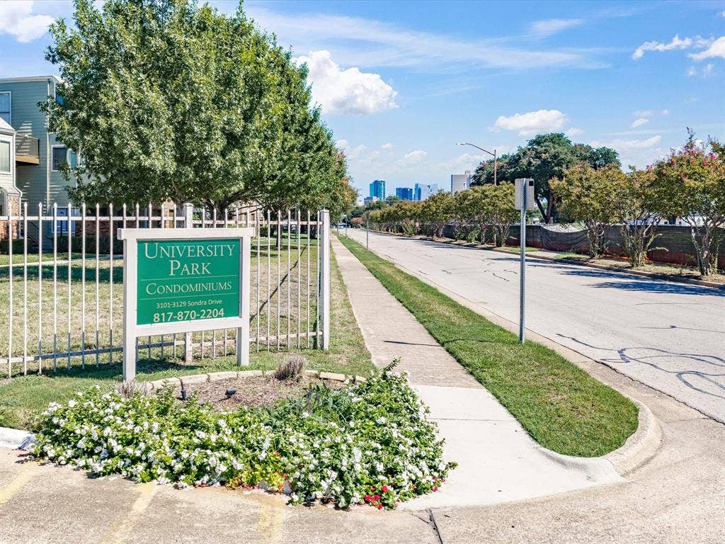 3129 Sondra Drive, #206, Fort Worth, TX 76107 University Park Condominiums signage with white fencing, bordered by mature trees and a manicured lawn