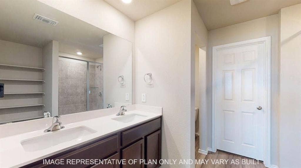 10108 Altair Drive, Waco, TX 76708 Double vanity with integrated sinks, dark wood-finish cabinetry, and a large wall-mounted mirror