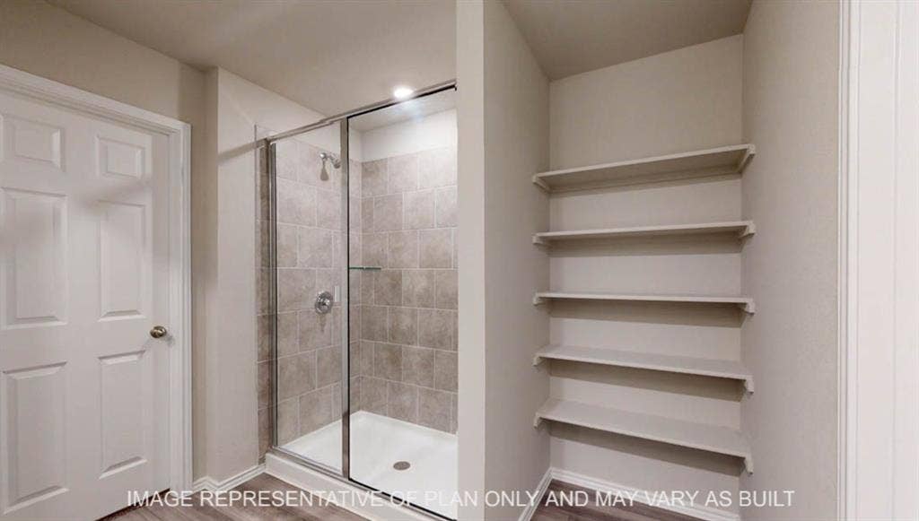 10108 Altair Drive, Waco, TX 76708 Walk-in shower with clear glass enclosure, tiled walls, and a built-in shelf