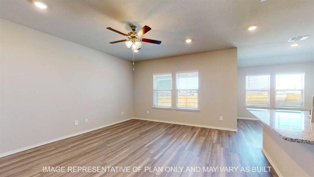 10108 Altair Drive, Waco, TX 76708 Wood-finish flooring, recessed lighting, ceiling fan with integrated light, multiple windows, and a breakfast bar with a speckled countertop