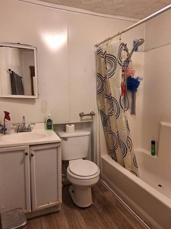 3308 King Street, Greenville, TX 75401 Bathroom featuring a built-in vanity with sink, toilet, and a shower-tub combination