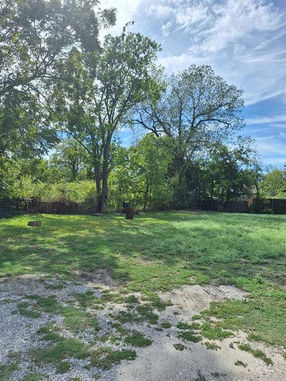3308 King Street, Greenville, TX 75401 Expansive green space featuring established trees and a partially graveled area