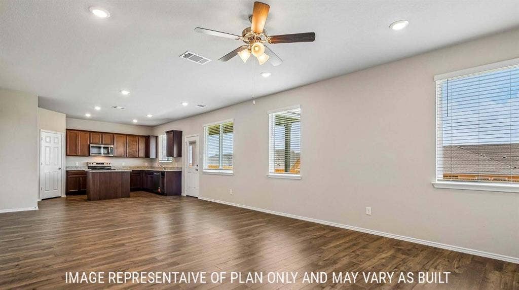 10101 Altair Drive, Waco, TX 76708 Wood-finish flooring, recessed lighting, ceiling fan, multiple windows, and a kitchen with wood cabinetry