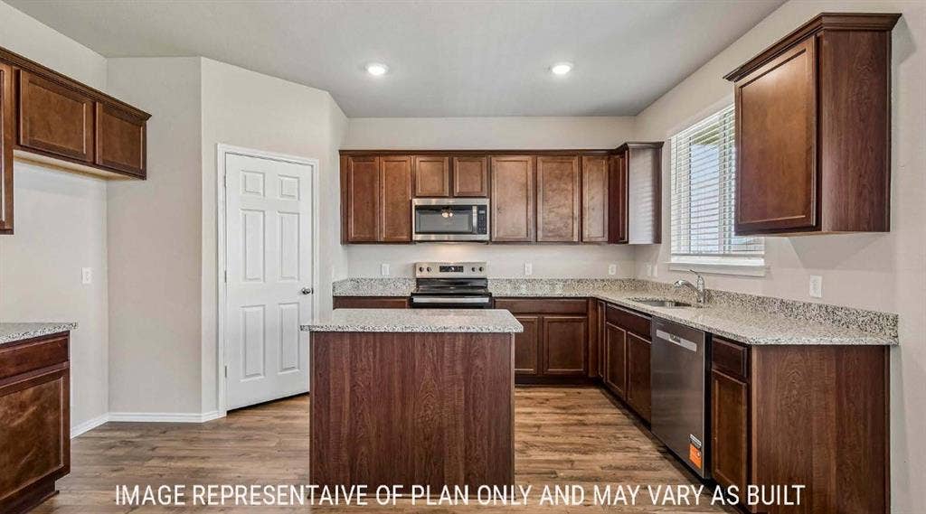 10101 Altair Drive, Waco, TX 76708 Wood-finish flooring, dark wood cabinetry, light-toned countertops, recessed lighting, and stainless-steel appliances