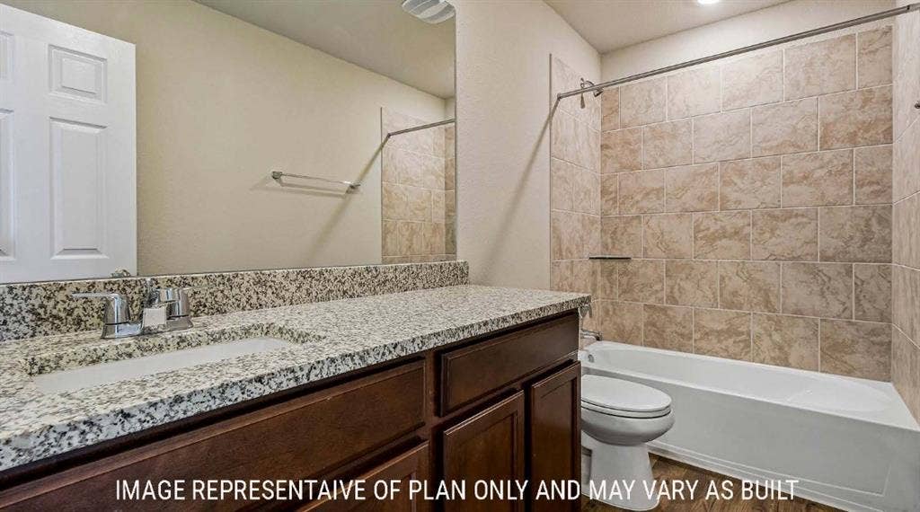10101 Altair Drive, Waco, TX 76708 Granite-style countertop with integrated sink, dark wood-finish vanity, and tiled shower surround with a built-in tub