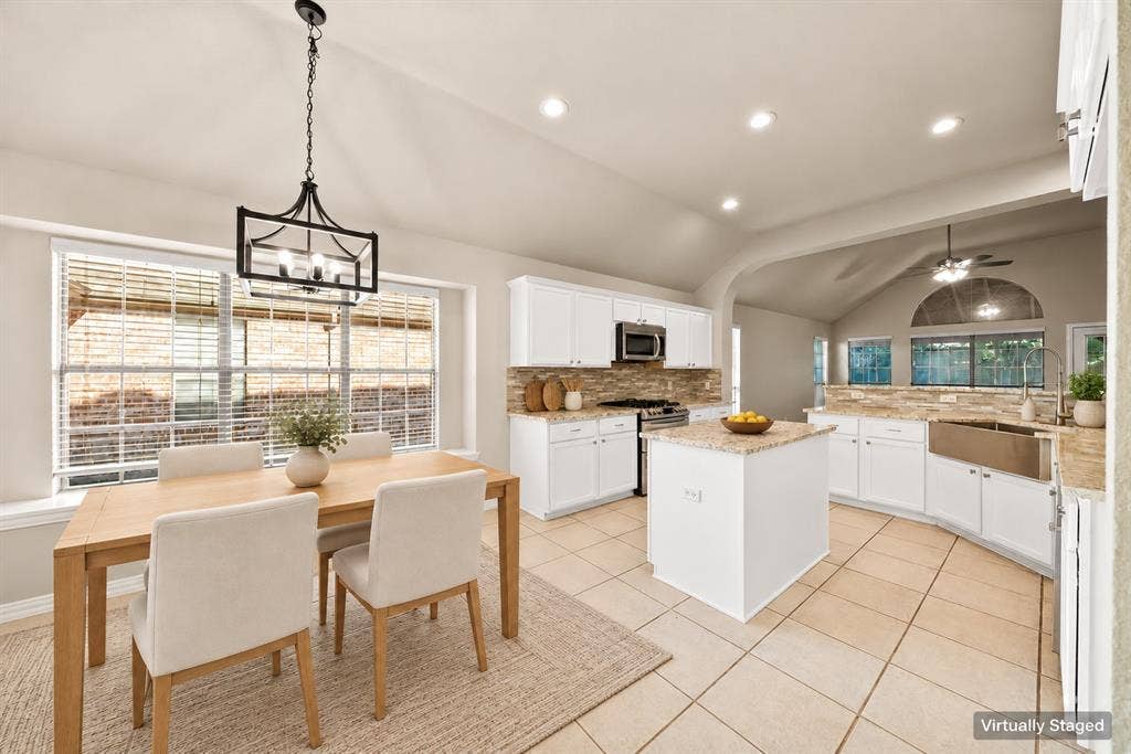 242 Cox Drive, Fate, TX 75087 Kitchen featuring white cabinetry, a central island, stainless steel appliances, stone countertops, and tile flooring
