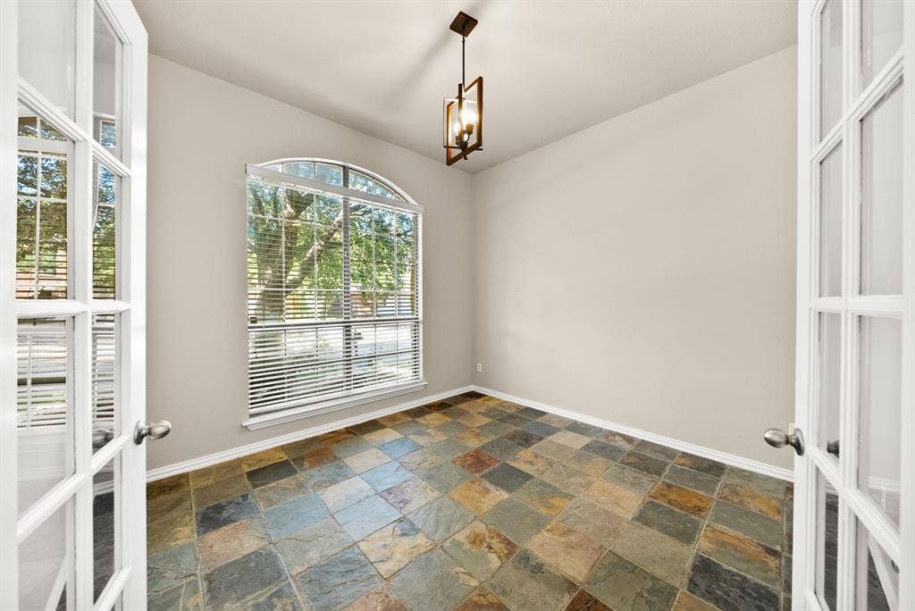 242 Cox Drive, Fate, TX 75087 Arched picture window, double French doors, multicolor slate tile flooring, and a ceiling-mounted light fixture