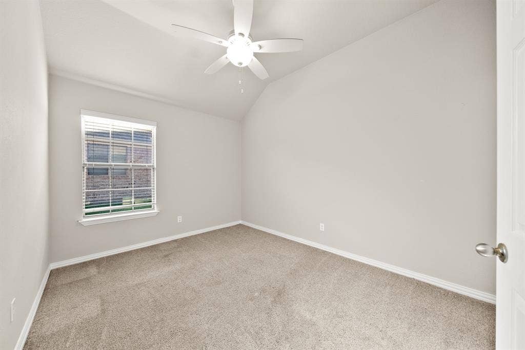 242 Cox Drive, Fate, TX 75087 Vaulted ceiling, ceiling fan with integrated lighting, window with blinds, carpet flooring, and a paneled door