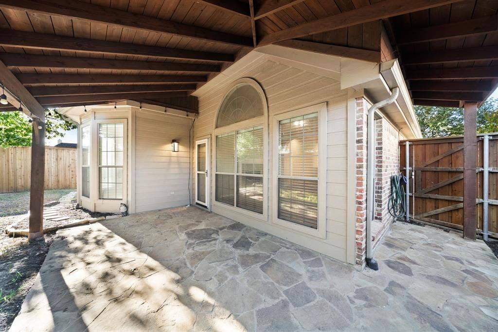 242 Cox Drive, Fate, TX 75087 Covered patio featuring flagstone paving, wood-plank ceiling, and exterior lighting