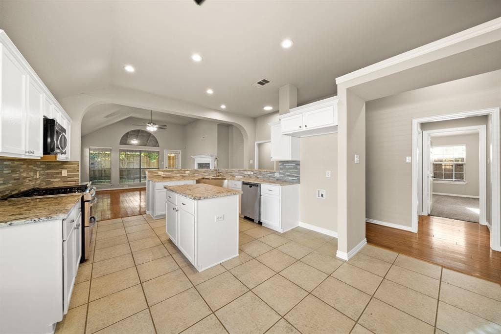 242 Cox Drive, Fate, TX 75087 Kitchen featuring white cabinetry, granite countertops, tile flooring, and stainless steel appliances