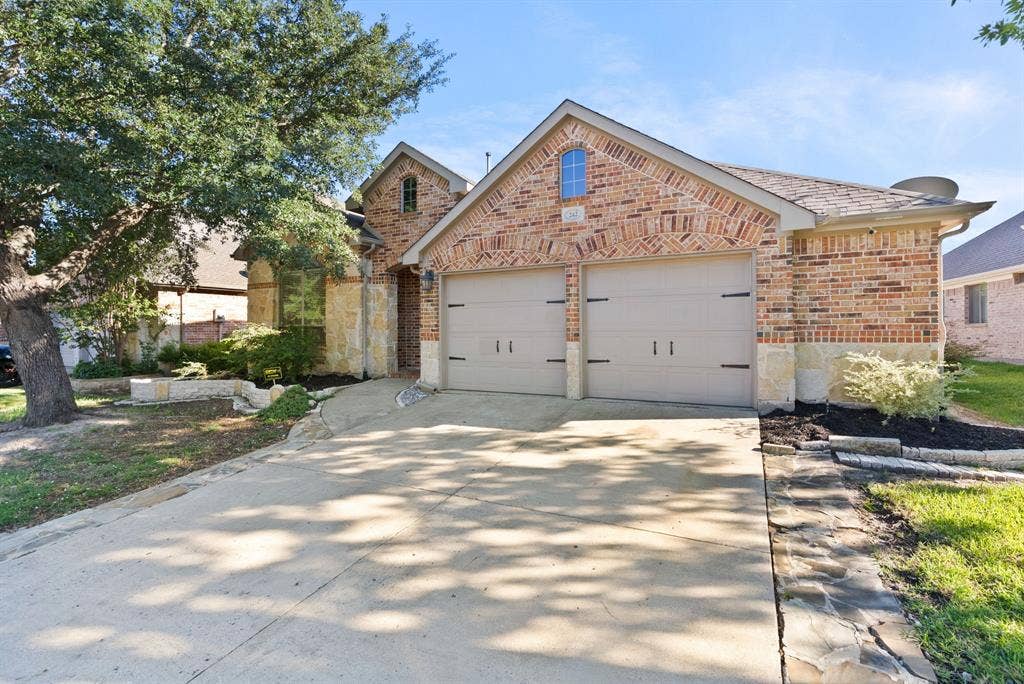 242 Cox Drive, Fate, TX 75087 Brick exterior with architectural detailing and arched entryway