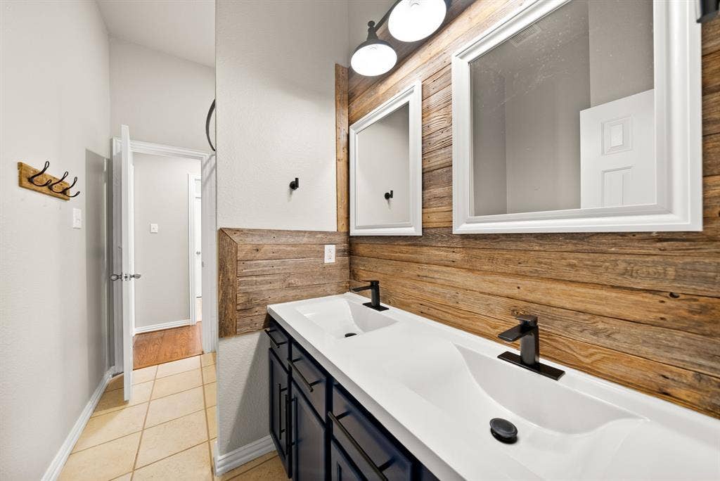 242 Cox Drive, Fate, TX 75087 Dual vanity with integrated sinks, dark wood-finish cabinetry, and matte black fixtures