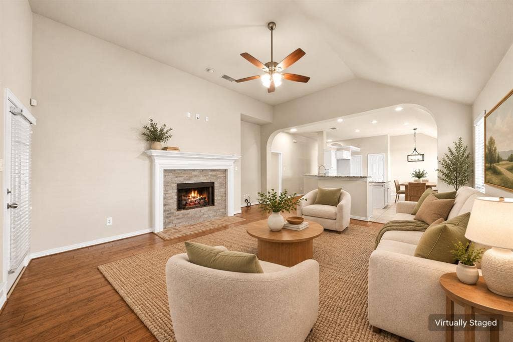 242 Cox Drive, Fate, TX 75087 Vaulted ceiling with a ceiling fan, stone-surround fireplace with a mantel, wood-finish flooring, and recessed lighting